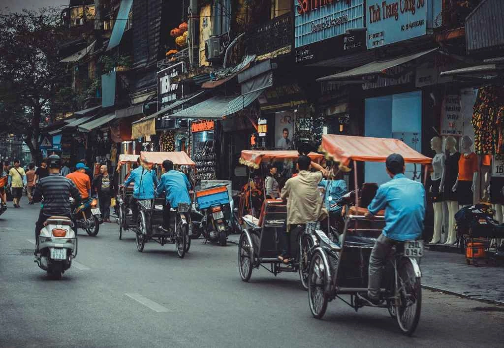 Risciò e motorini in una strada del quartiere vecchio di Hanoi, Vietnam