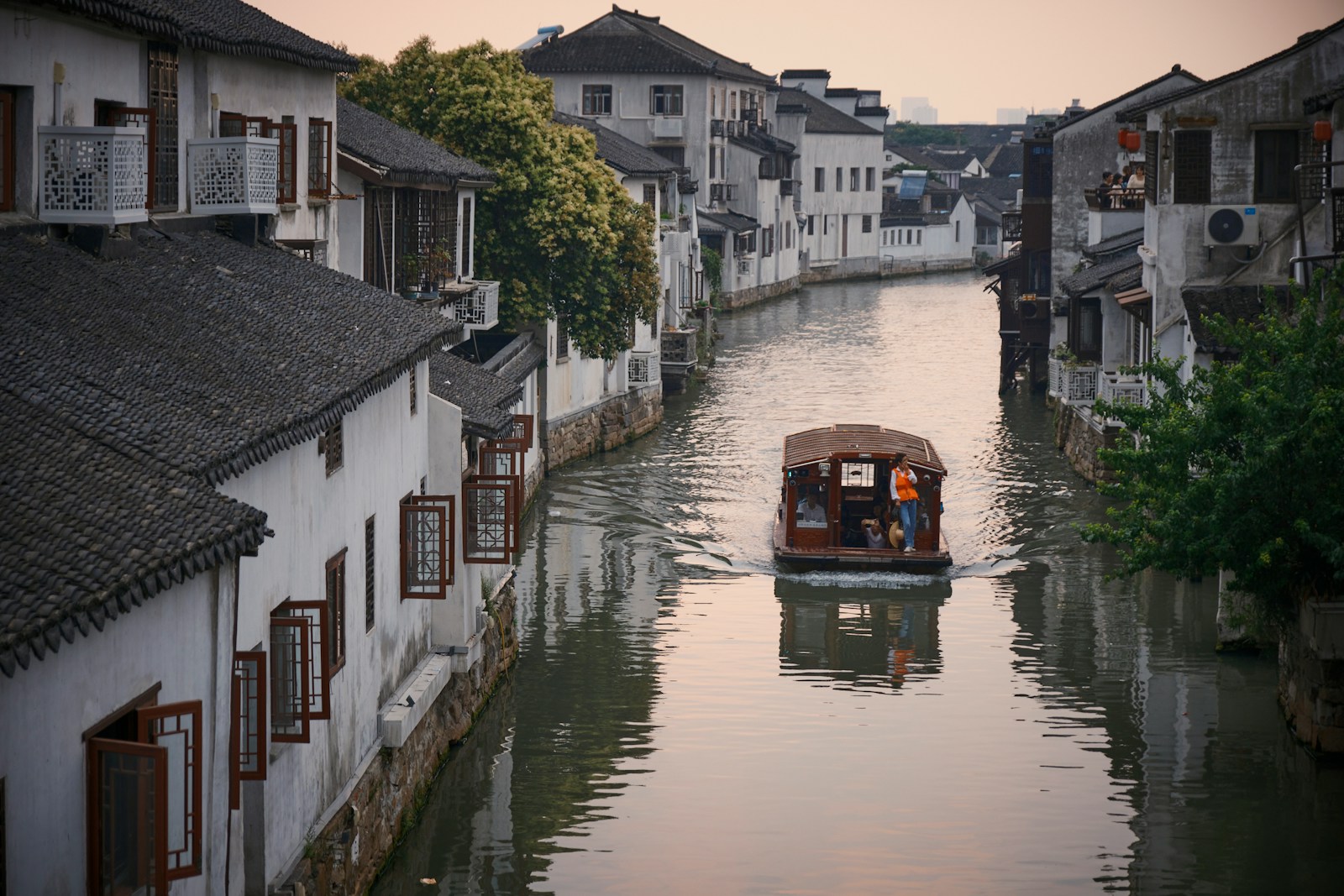 Barca su un canale tra le case bianche di Suzhou, la Venezia d'Oriente, Cina