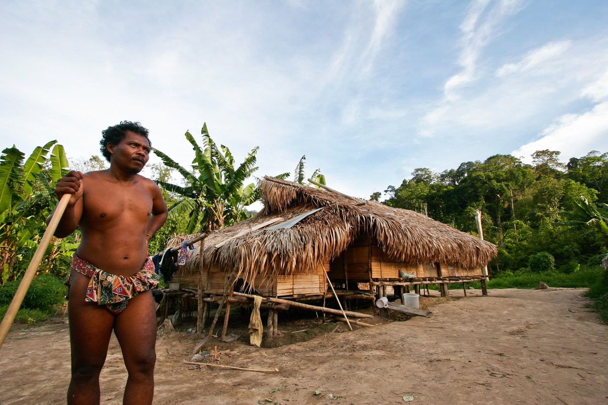 Uomo Orang Asli davanti alla capanna del villaggio nella foresta di Belum, Malesia